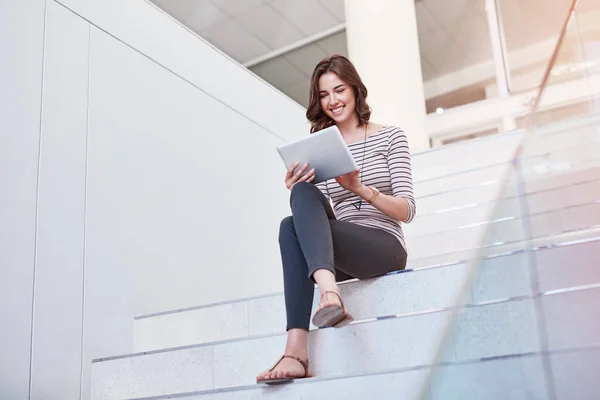 Snelle reacties zorgen voor een geweldige e-mail etiquette. Foto van een jonge zakenvrouw met een digitale tablet op de trap in een modern kantoor. — Stockfoto