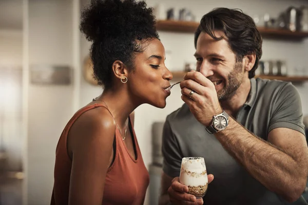 Et nous y voilà. Plan recadré d'un homme d'âge moyen affectueux nourrissant son dessert femme dans leur cuisine à la maison. — Photo