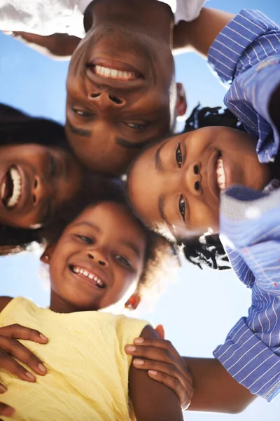 Ze zetten hun hoofden bij elkaar. Low view portret van een gelukkige Afrikaans-Amerikaanse familie die de dag samen doorbrengen op het strand. — Stockfoto