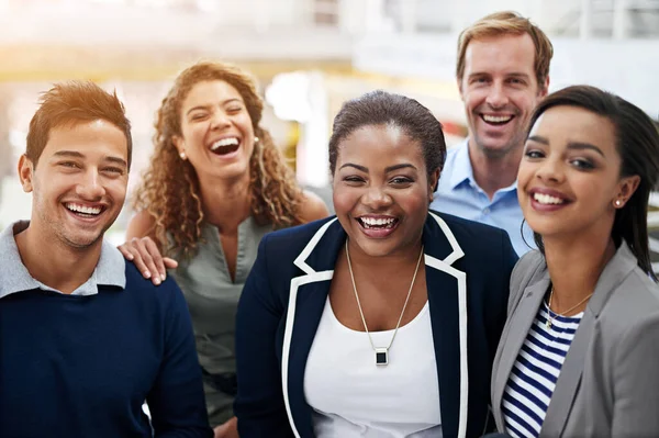 Samen kunnen we zoveel bereiken. Portret van een groep lachende collega 's die in een kantoor staan. — Stockfoto