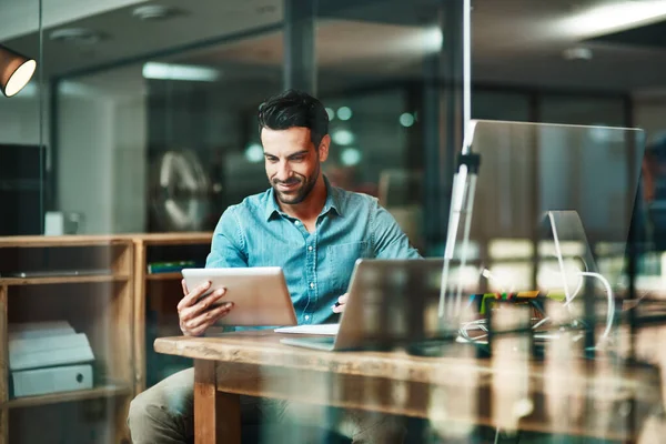 O trabalhador digital faz as coisas. Tiro de um jovem empresário usando um tablet digital em sua mesa em um escritório moderno. — Fotografia de Stock