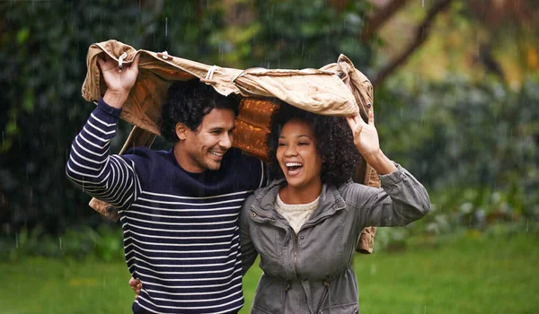 Presto, mettiti sotto la mia giacca. Colpo ritagliato di una giovane coppia affettuosa che cerca di sfuggire alla pioggia. — Foto Stock