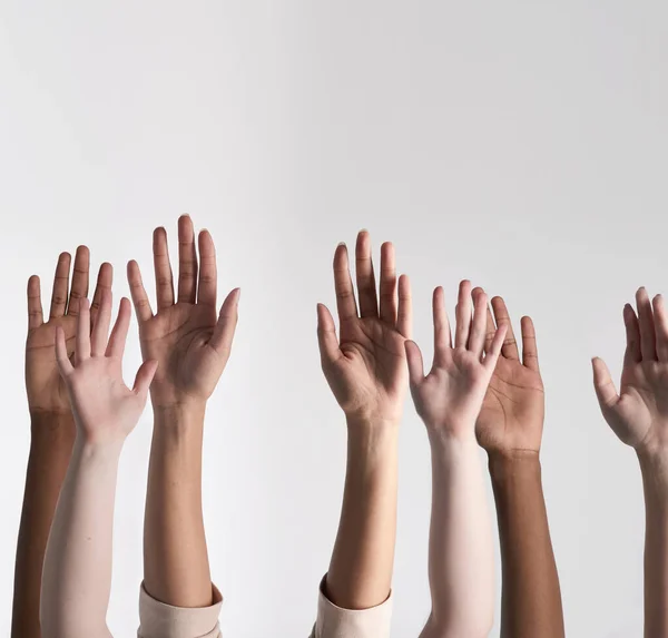 Making their voices heard. Shot of a diverse group of unidentifiable people holding their hands up against a white background. — Stock Photo, Image
