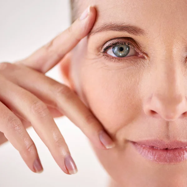 Onder de indruk van de resultaten van haar anti-aging crème. Close-up studio portret van een aantrekkelijke volwassen vrouw. — Stockfoto