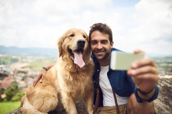 En baştan bir tane daha. Yakışıklı bir genç adam ve köpeğinin dağlarda yürüyüş yaparken selfie çekerken tam boy çekimleri.. — Stok fotoğraf