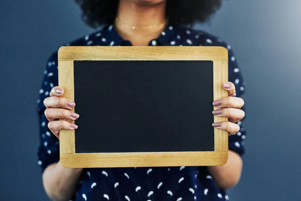 Haben Sie schon gehört. Ausgeschnittene Studioaufnahme einer Frau, die eine leere Tafel vor blauem Hintergrund hält. — Stockfoto