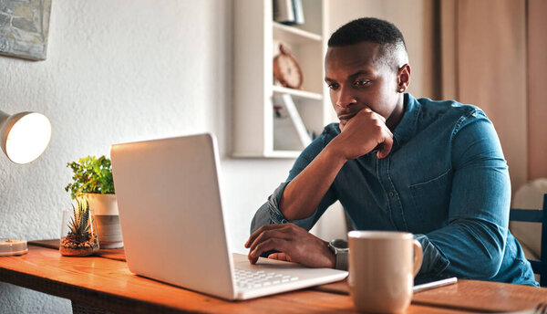 Это действительно лучший бизнес-ход. Обрезанный снимок красивого молодого бизнесмена, сидящего в своем домашнем офисе и смотрящего созерцательно во время работы над ноутбуком.