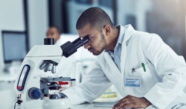 Başarı asla durmaz, hastalıklar da öyle. Laboratuvarında çalışan genç bir bilim adamının görüntüsü..