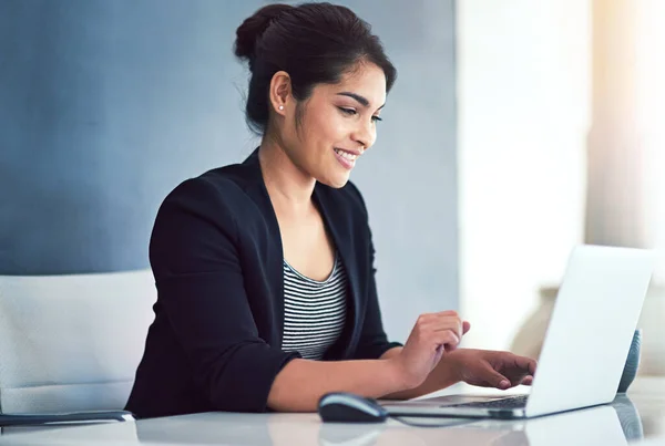 Jobbnöjdhetskontroll. Beskuren bild av en attraktiv ung affärskvinna som arbetar på en bärbar dator på sitt kontor. — Stockfoto