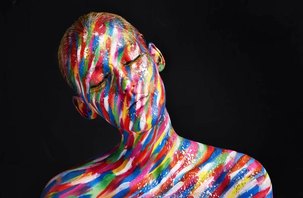 Atrévete a hacer belleza diferente. Foto de estudio de una joven posando con pintura de colores brillantes en su cara sobre un fondo negro. —  Fotos de Stock