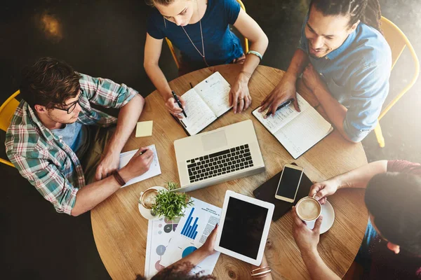 La tecnologia è una risorsa fantastica per gli strumenti di studio. Colpo ad angolo alto di un gruppo di studenti che studiano in una caffetteria. — Foto Stock