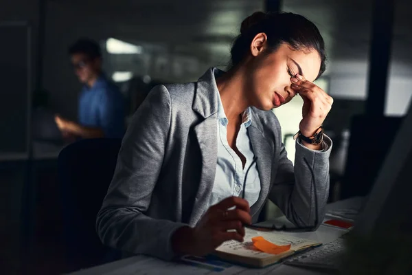 Utbränd, inte bra för dig eller affärerna. Beskuren bild av en ung attraktiv affärskvinna som arbetar sent på kvällen på kontoret. — Stockfoto