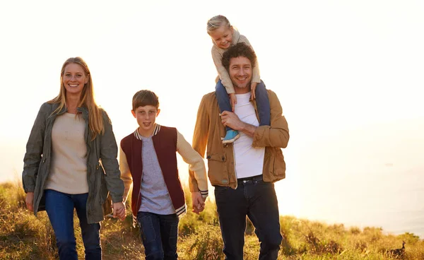 Stärka familjebandet. Skjuten av en lycklig familj ute på en morgonpromenad tillsammans. — Stockfoto