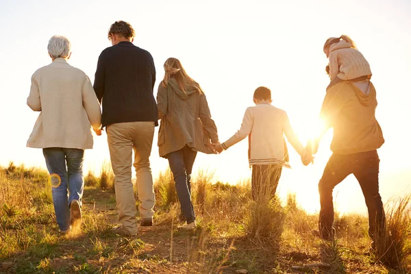 Ztracen v klidu. Snímek šťastné rodiny držící se za ruce na ranní procházce spolu. — Stock fotografie