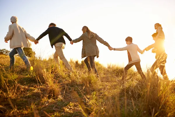 Säkra i varandras händer. Skjuten av en lycklig familj med händerna på en morgonpromenad tillsammans. — Stockfoto