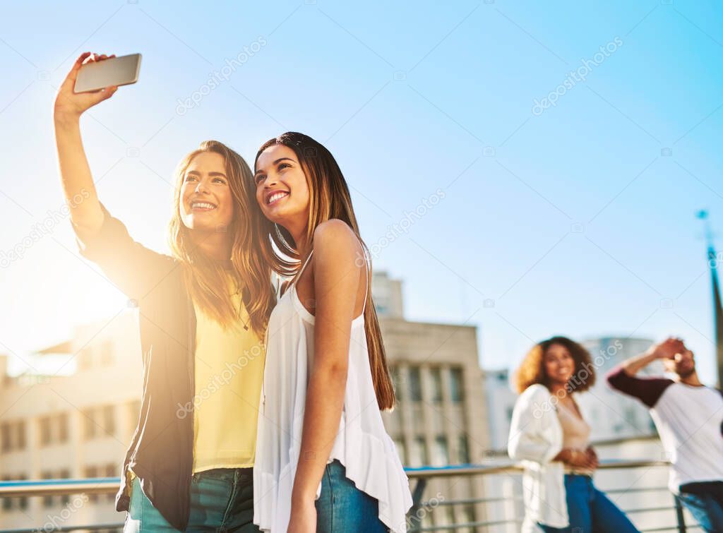 Together with each other is our favourite place to be. Shot of young female friends taking a selfie outside.