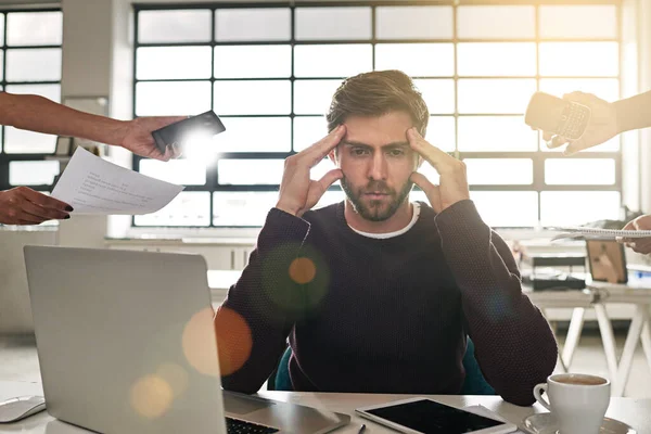 Preciso de ajuda. Tiro de um empresário estressado cercado por colegas que precisam de ajuda. — Fotografia de Stock