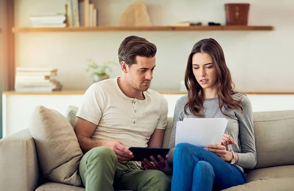 Ottenere una buona comprensione delle loro finanze nazionali. Girato di una giovane coppia che esaminava le scartoffie insieme a casa. — Foto Stock