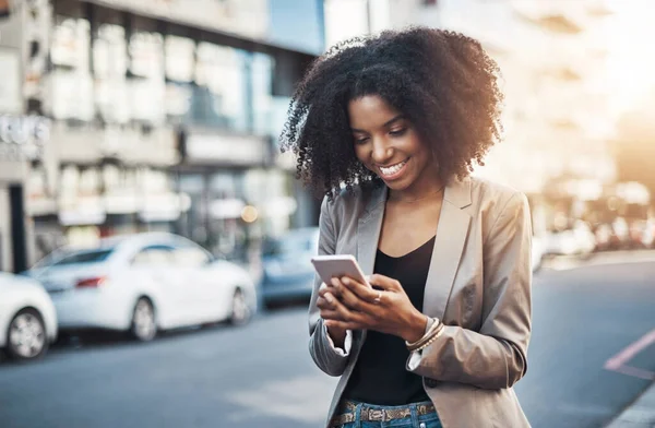 Adoro quando ricevo messaggi con buone notizie. Girato di una giovane donna d'affari che usa un cellulare in città. — Foto Stock