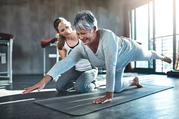 Zusammenarbeit zur Verbesserung von Muskelkraft und Spannkraft. Aufnahme einer Seniorin beim Training mit ihrem Physiotherapeuten. — Stockfoto