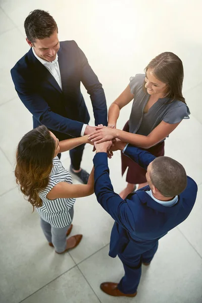 Teamwork is een van de grootste componenten van succes. Hoge hoek opname van een groep zakenmensen die hun handen samenvoegen in eenheid. — Stockfoto
