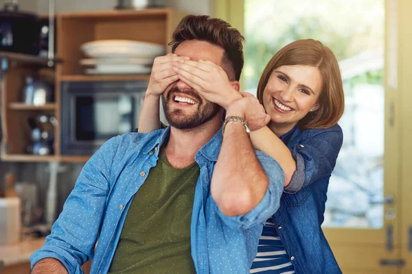 Think he knows its me. Portrait of a happy young woman playfully covering her husbands eyes. — Stock Photo, Image