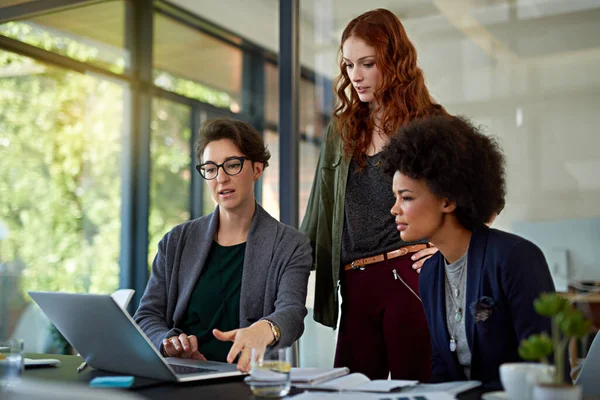 Leur travail repose sur l'excellence. Coup de projectile de collègues travaillant ensemble sur un ordinateur portable dans un bureau moderne. — Photo