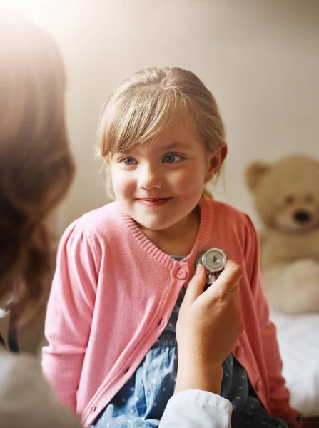 Einfach mal eine Routineuntersuchung. Aufnahme eines Arztes, der ein kleines Mädchen mit einem Stethoskop in ihrem Sprechzimmer untersucht. — Stockfoto