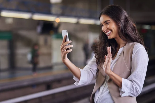 Ik zeg hallo tegen de mensen thuis. Gesneden schot van een jonge aantrekkelijke vrouw video bellen met haar mobiele telefoon tijdens het woon-werkverkeer met de trein. — Stockfoto