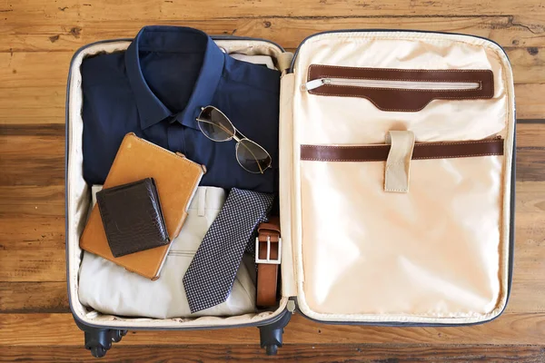 Minden készen áll az indulásra. Nagy látószögű felvétel egy bőröndről, tele különböző lényeges dolgokkal egy utazó üzletember számára.. — Stock Fotó