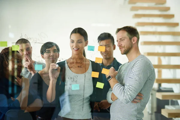 Planning is the first step. Cropped shot of a group of young designers planning on a glass board. — Stock Photo, Image