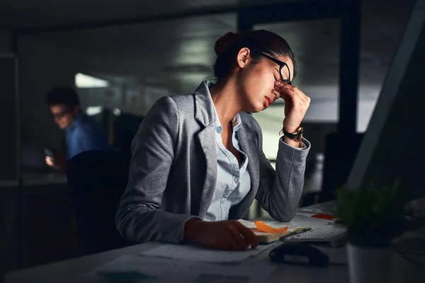 To był długi dzień. Zdjęcia młodej, atrakcyjnej bizneswoman pracującej do późna w nowoczesnym biurze. — Zdjęcie stockowe