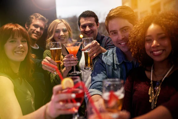 Lchaim. Retrato de um grupo de pessoas brindando com suas bebidas em uma boate. — Fotografia de Stock