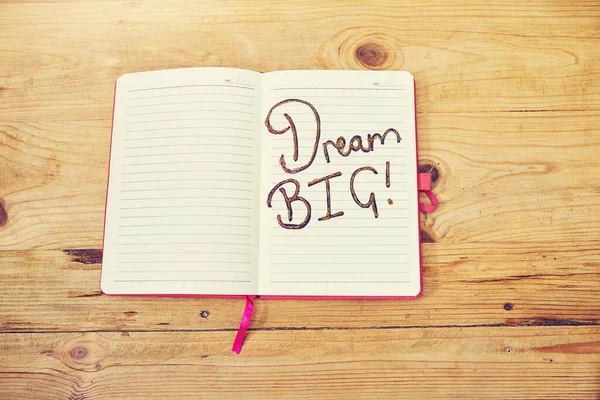 Άσε τα όνειρά σου να δουλέψουν για σένα. Υψηλής γωνίας πλάνο ενός δημιουργικού σταθμού εργασίας με ένα σημειωματάριο που έχει τις λέξεις όνειρο bigwritten σε αυτό. — Φωτογραφία Αρχείου