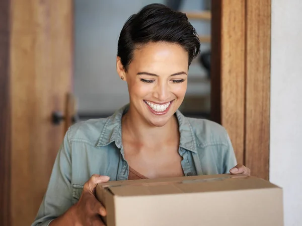 Giusto in tempo. Girato di una giovane donna sorridente in piedi alla sua porta d'ingresso che riceve un pacco da un corriere. — Foto Stock