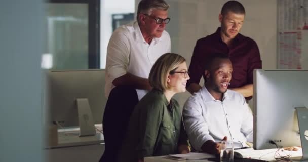 Maximizar a cada minuto do dia e da noite. 4k vídeo de um grupo de empresários que trabalham tarde em um computador em um escritório. — Vídeo de Stock