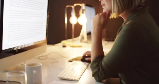 Le notti tarde sono una parte del percorso verso il successo. 4k video di una giovane donna d'affari che lavora fino a tardi su un computer in un ufficio. — Video Stock