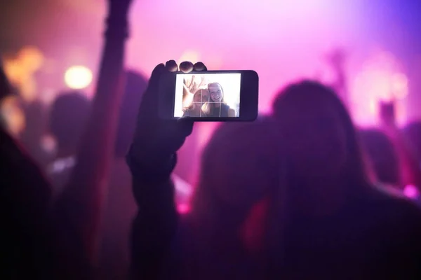 Shot of a fan filming a concert on their camera. This concert was created for the sole purpose of this photo shoot, featuring 300 models and 3 live bands. All people in this shoot are model released. — Stock Photo, Image