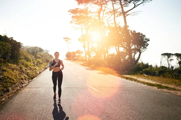 Ponte a correr por una quemadura de cuerpo entero. Tiro de una joven en forma que va a correr al aire libre. —  Fotos de Stock
