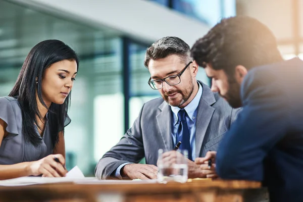 Decidir sobre sus opciones más factibles para seguir adelante. Fotografía de un grupo de colegas trabajando juntos en una oficina. — Foto de Stock