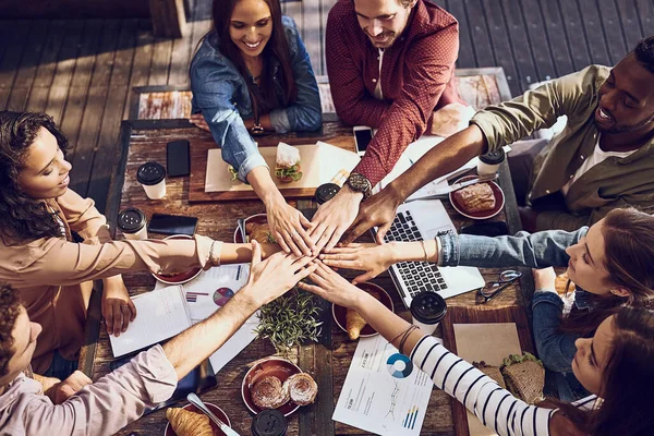 Essen inspiriert alle. Aufnahme einer Gruppe kreativer Arbeiter, die sich beim Geschäftsessen die Hände stapeln. — Stockfoto