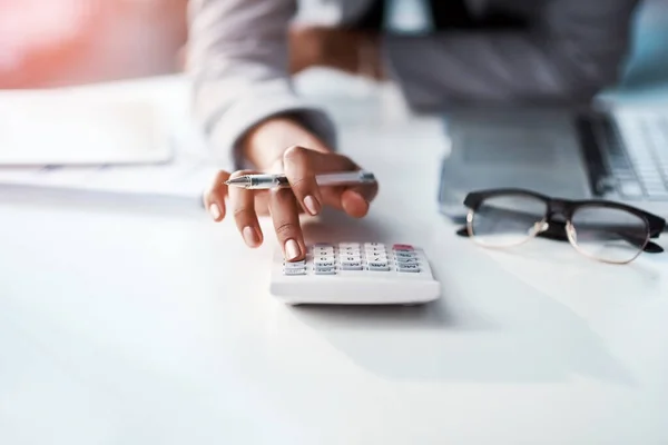 Каждый бизнес-шаг имеет финансовый результат. Обрезанный снимок деловой женщины с помощью калькулятора за ее столом в современном офисе. — стоковое фото