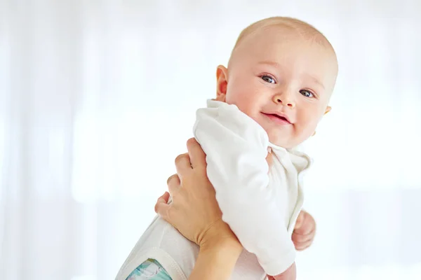 Livet føles ganske bra herfra. Et bilde av en gutt som blir holdt av foreldrene hjemme.. – stockfoto