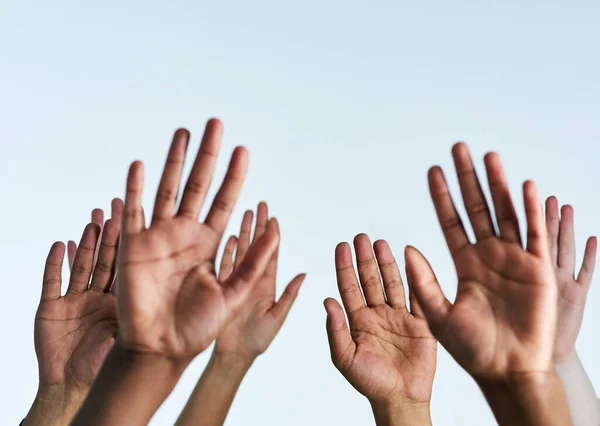 Steek je handen op ter ondersteuning van elkaar. Schot van een groep handen reikend tot tegen een witte achtergrond. — Stockfoto
