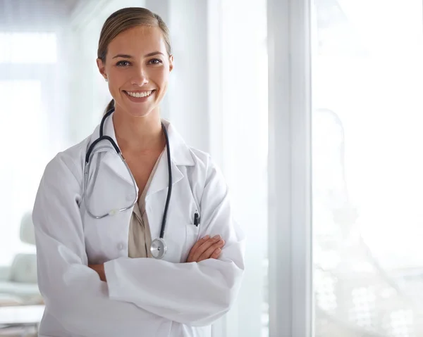 Confía en ella. Retrato de una atractiva joven doctora de pie con los brazos cruzados. —  Fotos de Stock