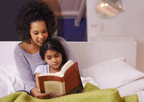 Czytam jej bajkę na dobranoc. Ujęcie młodej matki czytającej córce w domu.. — Zdjęcie stockowe