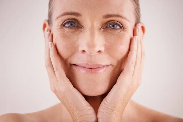 Te ves absolutamente encantadora. Retrato de estudio de una hermosa mujer madura posando con la cabeza en las manos. — Foto de Stock