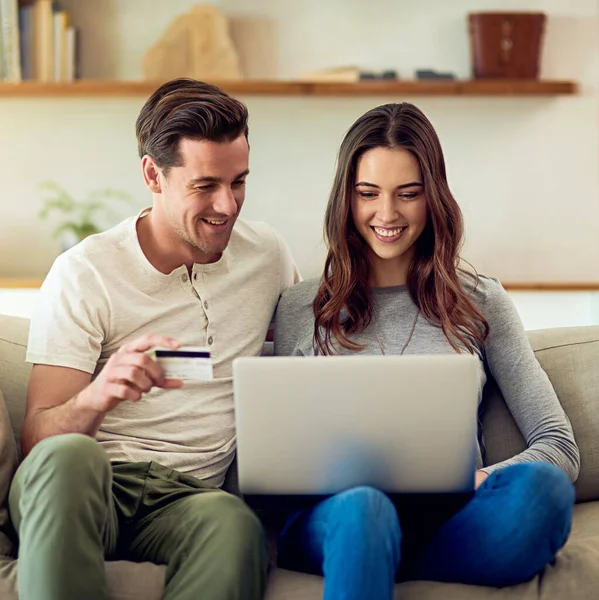 Купуйте онлайн і перекидайте торгову лінію. Постріл щасливої молодої пари, що робить оплату кредитною карткою на ноутбуці разом вдома . — стокове фото