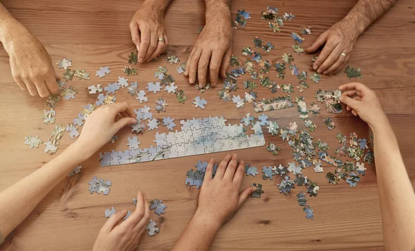 Soluzioni per puzzle. Girato di un gruppo di persone che costruiscono un puzzle insieme. — Foto Stock