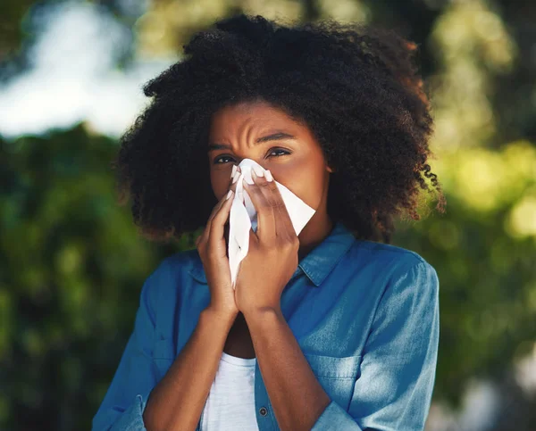 Az allergiaszezon... Egy fiatal nő portréja, amint kifújja az orrát egy zsebkendővel odakint.. — Stock Fotó